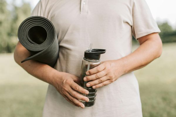 A pair of hands holding a water bottle after a workout session.